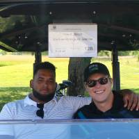 2 men in golf cart in the shade